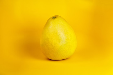 Pomelo citrus fruit with yellow thick rind on yellow background