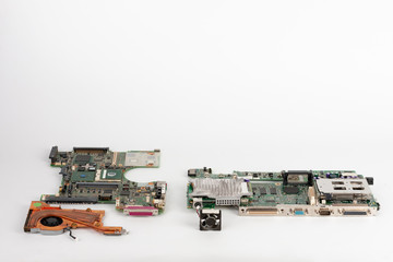 Comparing two laptop mother boards  with fans, one with orange fan from 2003, one from 1999