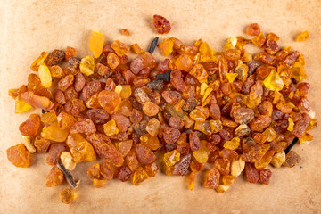 Small amber stones on a gray piece of paper. A pile of small ambers found on the Baltic beach.