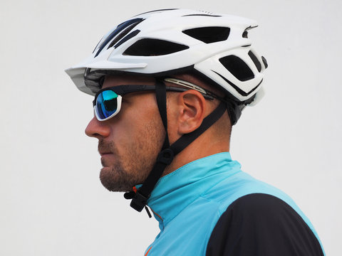 Profile of a cyclist, wearing a helmet and sunglasses.