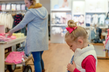 Mother and daughter shopping for kids clothes