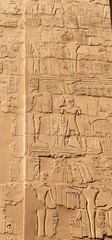 Karnak Temple, complex of Amun-Re. Great Hypostyle Hall. Embossed hieroglyphics on columns and walls. Min  is an ancient Egyptian god. Luxor Governorate, Egypt.