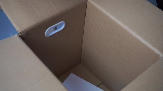 Businessman takes documents from unpacks cardboard boxes in new workplace office, pick moving to new work offices for first day at new job, beginning or starting to company. work carrying box