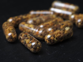 Bee pollen grains  in clear capsules for daily use. Healthy natural medicine for influenza.