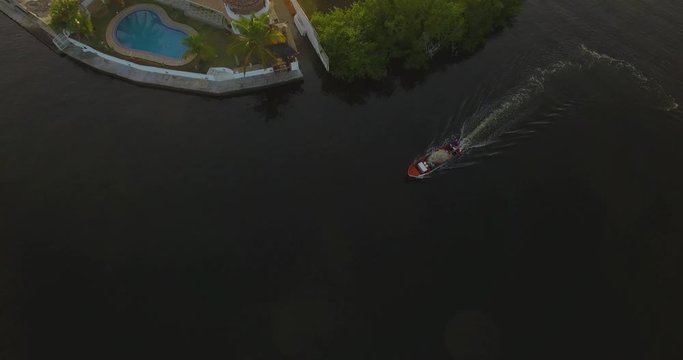 Drone view following a fishing boat cruising the Higuerote canals in Venezuela