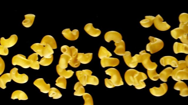 Super slow motion of flying uncooked italian pasta chifferi on black background. Filmed on high speed cinema camera, 1000 fps.
