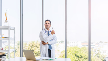 Asian doctor in gown uniform working with happiness smiling at hospital or medical clinic