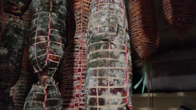 Production Of Sausages Homemade. Italian Different Traditional Salami And Bacon Smoked Arranged In A Row. Smoked Capocollo And Sopressata, Calabria In Italy, Pork Hanging To Dry It. Spicy Sausages.