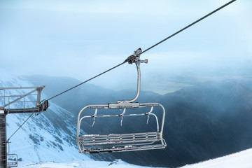 ski lift in mountains, ski lift chair transports skiers and snowboards up ski field mountains