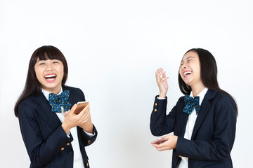 スマートフォンを持つ女子学生2人