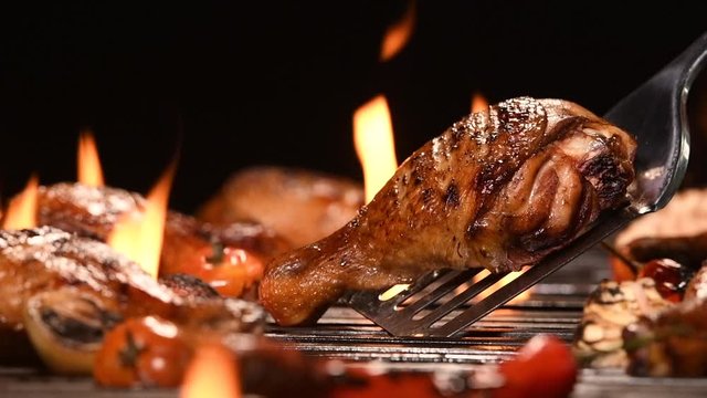 Close up grill roast bbq chicken leg on the flaming grill , HD slow motion