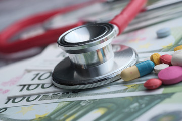 Close up of cash, pills and stethoscope 