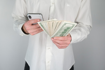 Man holds money and phone in his hands.
