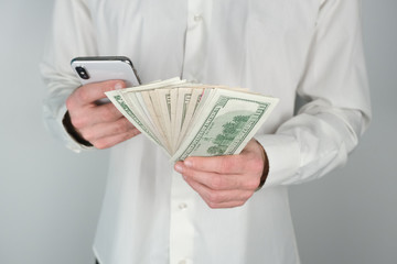 Man holds money and phone in his hands.