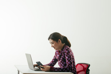 woman working with her phone and laptop