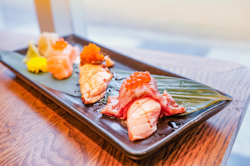Japanese food, a set of sushi put on a rectangular plate placed on wooden table