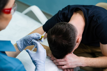 Obraz na płótnie Canvas Injection plasma into head hair man cosmetologist doctor