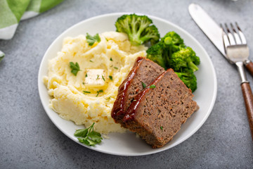 Meatloaf with spicy glaze sliced on a plate with mashed potatoes and broccoli, ground beef and pork dish - Powered by Adobe