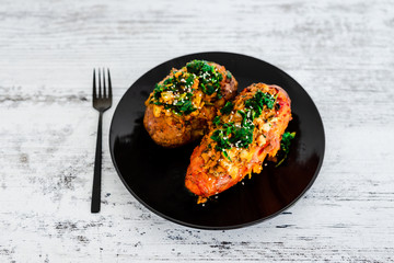 plant-based food, baked veggie-stuffed potato and sweet potato with beans and spinach topping
