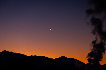 Obraz premium Beautiful morning sunrise over silhouette of Utah mountain range with large factory smoke stack