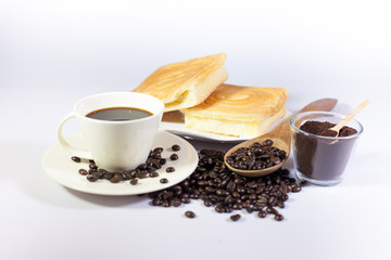 Black coffee roasted coffee beans with bread and spoon