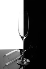 Two empty glasses of champagne with reflection, on a white and black gradient background. Club life concept.