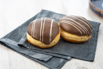 Donut or bun made from sweet yeast dough stuffed with chocolate and icing. Confectionery - Berliner Pfannkuchen.
