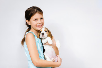 Teen girl holding beagle dog.