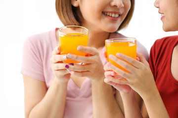 Happy young couple friend beautiful asia women drinking orange juice enjoying fruit refreshment ,Healthy lifestyle concept.