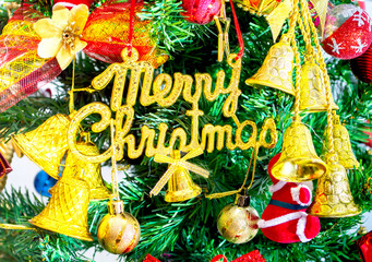 Naklejka premium gold merry chirstmas word and Ornaments on christmas tree isolate on white background