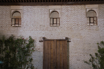 Moorish ornaments door entrance in the Alhambra in Granada, Spain One of the arch entrances to the palace and fortress of the Alhambra