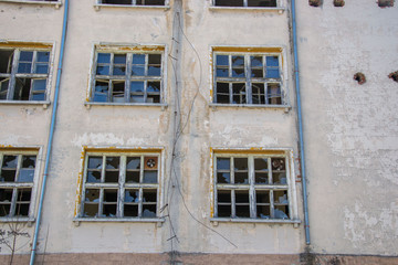 Broken damaged glass windows on a building, outdoors. Damaged window. Abandoned concept