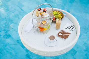 Breakfast and afternoon tea set floating around swimming pool