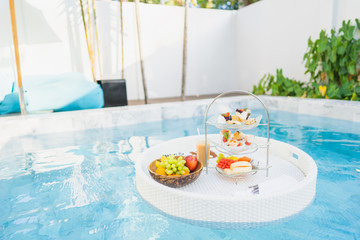 Breakfast and afternoon tea set floating around swimming pool