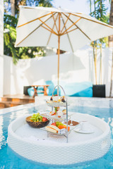 Breakfast and afternoon tea set floating around swimming pool