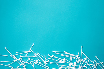 Flat lay composition with cotton swabs on blue background. Top view ear sticks