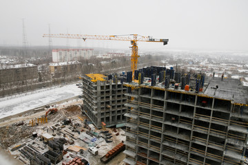construction of a multi-storey residential building at winter time.