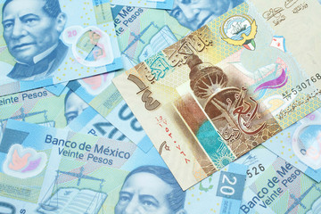 A colorful quarter dinar bank note from Kuwait close up in macro with Mexican twenty peso bank notes