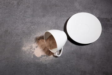 Poured cup of instant coffee granules on the gray stone texture