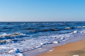 Image of sea foam on a sandy beach.