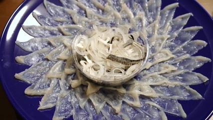 JAPANESE FOOD: Delicious fresh fugu sashimi (Puffer Fish) on dish, top view. Shot in 4K