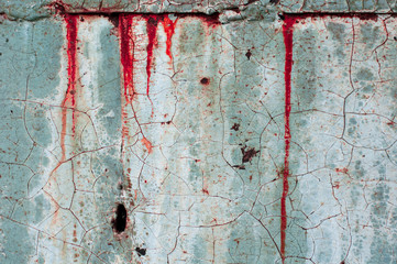 A bluish wall, naturally aged. Veins and holes. Peeling old paint. Scary and dark.
