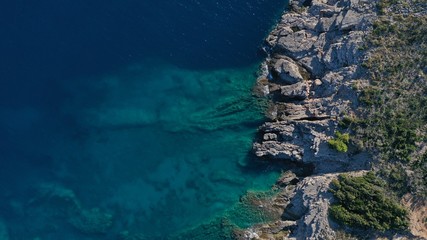 Aerial view of Kotor bay, Lustica peninsula, Montenegro natural landscape. Rocky coastline, azure water surface with foaming waves. Huge stones underwater.