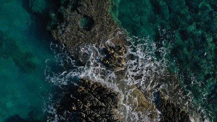 Aerial view of Kotor bay, Lustica peninsula, Montenegro natural landscape. Rocky coastline, azure water surface with foaming waves. Huge stones underwater.