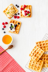 Beautiful yummy snacks. Waffles with cream and friuits on white background top-down frame copy space
