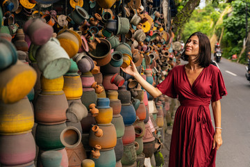 Attractive female person looking at colorful pottery