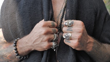 male hands open a heart-shaped tattoo on the chest