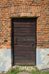 Old wooden door in brick wall