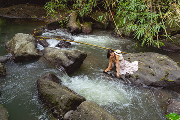 Fototapeta na wymiar Barefoot woman on mountain river in jungles stock photo