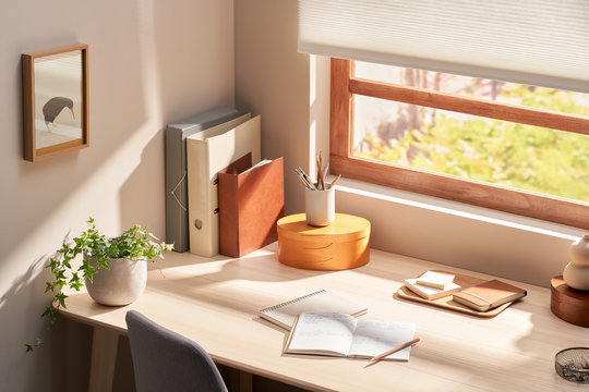 Desk with stationery near window in soft light